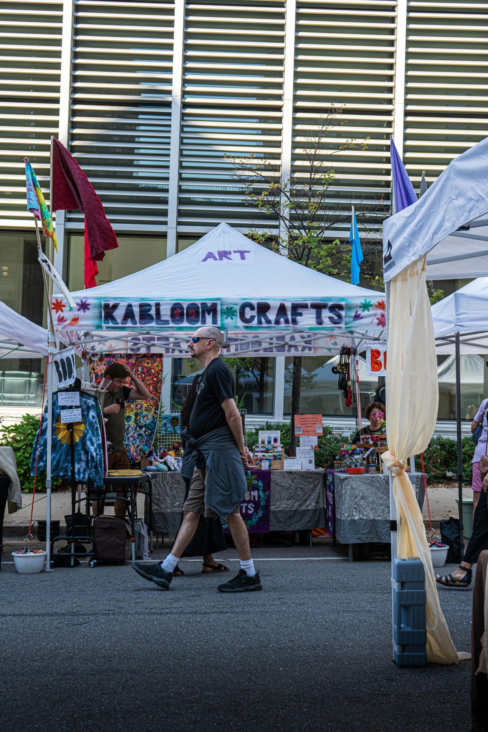 Colorful artisan booth display at Grand Rapids street fair with crafts and vendors.